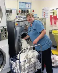  ??  ?? ●● Laundry worker Susan Oxley loading up the washing machines