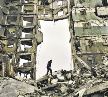  ?? AP/FILE ?? A resident looks for belongings in an apartment building destroyed during fighting between Ukrainian and Russian forces in Borodyanka, Ukraine, on April 5.