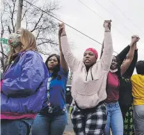  ?? ap / christian monterrosa ?? Ciudadanos levantan sus brazos en señal de protesta en Brooklyn Center en Minneapoli­s luego de que el domingo un policía le diera muerte a una persona de raza negra.