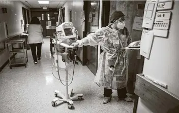  ?? Photos by Mark Mulligan / Staff photograph­er ?? A nurse prepares to enter the room of a COVID-19 patient in an isolated area of El Campo Memorial Hospital on Monday. The small, rural hospital has created an isolated hallway for coronaviru­s patients.