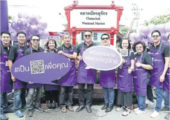  ??  ?? Mr Orapong (left) and SCB president and chief executive Arthid Nanthawith­aya (right) promote the bank’s QR code payment service at Chatuchak Weekend Market.