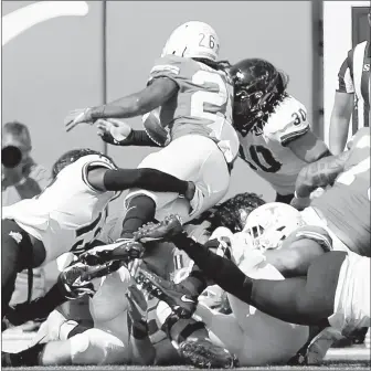  ?? TIM WARNER/GETTY-AFP ?? TCU’s Garret Wallow (30) forces a fumble by Texas’ Keaontay Ingram on the goal line late in the fourth quarter.