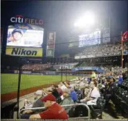  ?? FRANK FRANKLIN II — ASSOCIATED PRESS ?? Spectators at Citi Field watch a game between the Mets and Rockies in July from behind a net.