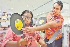  ?? Picture: ELIKI NUKUTABU ?? Ravinay Pillay of Nausori, is shown the different sizes of Premier non-stick round tawa, by Courts sales rep Roko Uluilakeba at Courts Nakasi.