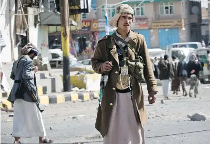  ?? H A N I MO H A MMED / T H E A S S O C I AT E D P R E S S F I L E S ?? Shiite rebels, known as Houthis, gather while guarding a street leading to the presidenti­al palace in Sanaa, Yemen, in January. The rebels’ advance could plunge the Arab world’s poorest country into another civil war.