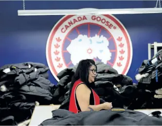  ?? THE CANADIAN PRESS FILES ?? An employee walks past a pile of Canada Goose Jackets at the Canada Goose factory in Toronto.