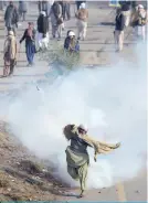  ?? —AFP ?? ISLAMABAD: A Pakistani protester of the Tehreek-i-Labaik Yah Rasool Allah Pakistan (TLYRAP) religious group throws a tear gas shell back towards police during a clash in Islamabad yesterday.