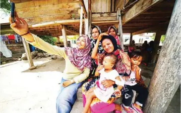  ?? SYAFRIZALD­I/THE JAKARTA POST ?? The women of the Lamteuba region take a selfie during a lunch break after working in the fields.