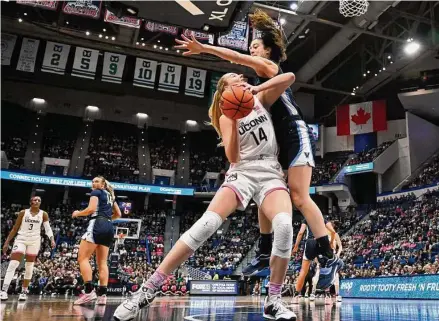  ?? Jessica Hill / Associated Press ?? UConn’s Dorka Juhasz, left, is pressured by Villanova’s Maddy Siegrist in the first half on Sunday in Hartford.