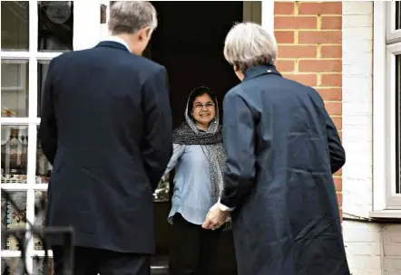  ?? Leon Neal/AFP ?? Theresa May (de costas) toca campainhas para pedir votos com o parlamenta­r conservado­r Zac Goldsmith em Londres