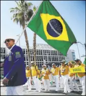  ??  ?? Luis Fernando Torres Cardozo marches in the Lions Parade of Nations on Saturday with his fellows from Brazil.