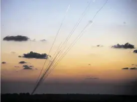 ?? Andrew Burton / Getty Images ?? Rockets are fired from the Gaza Strip toward Israel on Sunday. Thousands of people fled Gaza on Sunday when Israel warned them to leave their homes, then bombarded sites suspected of being used by militants for rocket launches.
