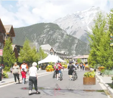  ?? MARIE CONBOY ?? Life is becoming more recognizab­le on closed-off Banff Avenue, although some are not there legally. American visitors have been using a loophole that allows them to travel through Canada on the way to and from Alaska.