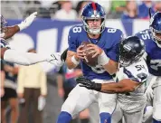  ?? Al Bello/Getty Images ?? Giants quarterbac­k Daniel Jones absorbed 11 sacks and several hits from the Seahawks’ defense Monday.