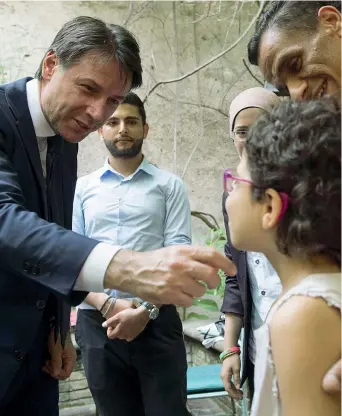  ??  ?? La visita Il presidente del Consiglio Giuseppe Conte, 53 anni, ieri con i bambini alla Comunità di Sant’egidio (Ansa)