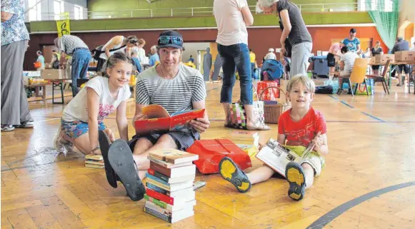  ?? FOTO: KIRSTEN LICHTINGER ?? Genug Lesestoff für die Ferien: Familie Vogel sichtet die Bücher vor dem Kauf.