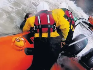  ??  ?? RNLI crew pull the surfer from the water