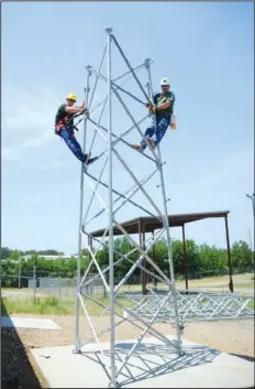  ??  ?? TALL ORDER: Charles Molsbee, communicat­ions maintenanc­e volunteer with the Garland County Department of Emergency Management, left, and Bob King, deputy director of the department, work on a portion of the new communicat­ions tower at the Department of...