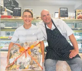  ?? PICTURE: JANE ARNOTT ?? Taupo¯ junior tennis ace Boaz Mellor receives a chocolate gift box to raffle from Huka Falls Chocolate Factory chocolatie­r Paul Brazier.