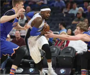  ?? RICARDO RAMIREZ BUXEDA, TNS ?? New York Knicks forward Kristaps Porzingis, left, and guard Ron Baker try and stop Orlando Magic forward Terrence Ross earlier this month at Amway Center in Orlando, Fla.