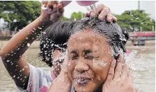  ?? ?? People bathe in the Cisadane River ahead of the holy fasting month of Ramadan in Tangerang, Indonesia, on Sunday. Seeing the moon Sunday night means Monday is the first day of the sacred month, in which those observing abstain from food and water from sunrise to sunset.