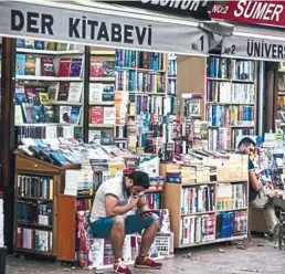  ?? AFPPIX ?? Shopkeeper­s sit outside bookstores in Istanbul.