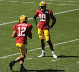  ?? DYLAN BUELL / GETTY ?? Aaron Rodgers participat­es in a drill as Jordan Love looks on during Green Bay Packers training camp at Lambeau Field on Aug. 20.