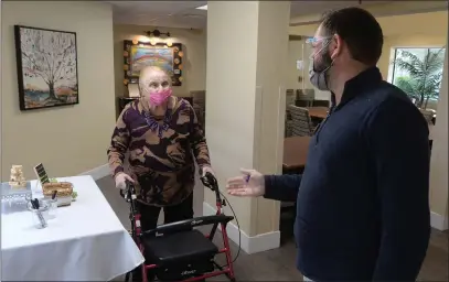  ?? ALAN DEP — MARIN INDEPENDEN­T JOURNAL ?? Florence Graham, a resident at Deer Park Retirement Community in Novato, chats with Robert Blaskey, the executive director, on Monday. The complex dining hall, which had been closed during most of the pandemic, has reopened.