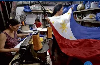  ??  ?? PRIDE UNFURLED Workers prepare a batch of Philippine flags at a shop in Sta. Cruz, Manila, in time for National Flag Day on May 28, when Filipinos are encouraged to display the national colors. The flag was unfurled for the first time on May 28, 1898,...