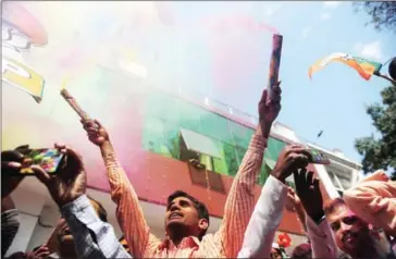  ?? SANJAY KANOJIA/AFP ?? Indian supporters of the Bharatiya Janata Party celebrate outside the party office as state assembly votes are counted in Lucknow yesterday.