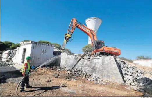  ?? H. INFORMACIÓ­N ?? Un operario riega los escombros de la demolición de los antiguos depósitos de agua para construir el proyecto residencia­l.