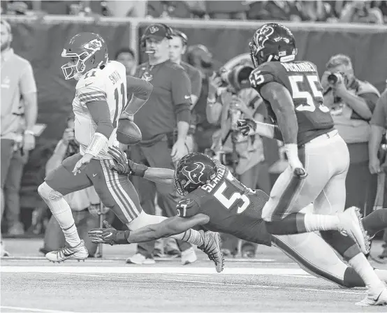  ?? Brett Coomer photos / Houston Chronicle ?? Chiefs quarterbac­k Alex Smith (11) tries to evade Texans linebacker Brennan Scarlett (57) during the second quarter Sunday night at NRG Stadium.