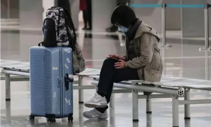  ?? Photograph: Tyrone Siu/Reuters ?? A passenger wears a protective face mask at an airport.