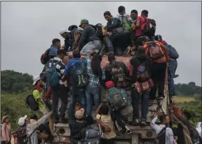  ?? ANGEL HERNANDEZ/DPA ?? Migrants jump on a truck in order not to have to walk a part of their long way on Saturday in Sayula, Veracruz, Mexico. Most of the migrants come from Honduras. They are currently on their way through Mexico towards the U.S. border.