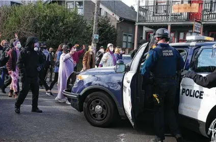  ?? Beth Nakamura / Associated Press ?? Protesters who have occupied a site to prevent a Black and Indigenous family from being evicted from a home on Tuesday took the foreclosed property back after morning clashes with police. Mayor Ted Wheeler called for an end to the occupation.