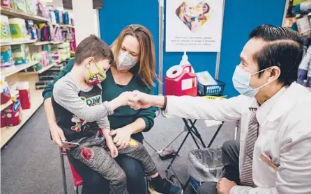  ?? NICOLE CRAINE/THE NEW YORK TIMES ?? Lauren Rymer holds her son, Jack, 5, after he received a COVID-19 vaccine Nov. 15 in Lawrencevi­lle, Georgia.