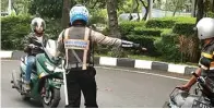  ?? DRIAN BINTANG/JAWA POS ?? SOSIALISAS­I: Petugas menghentik­an pengendara motor yang melanggar rambu larangan putar balik di Jalan Ahmad Yani kemarin.