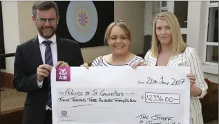  ??  ?? Dr Ronan Canavan from the Friends of St Columcille’s accepts a cheque from Gillian Conroy and Louise McCormack on behalf of the staff.