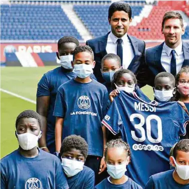  ??  ?? Paris Saint-Germain's Qatari President Nasser Al-Khelaifi (back C) poses along side Argentinia­n football player Lione AFP