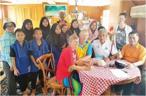  ??  ?? ZAINAL (duduk dua,kanan) bersama tetamu lain dan anak-anak RAY As Sakinah merakam gambar kenangan bersama pemilik kapal Restless M dari Australia ketika menaiki kapal berkenaan ke Pulau Manukan.