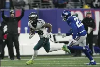  ?? BRYAN WOOLSTON — THE ASSOCIATED PRESS ?? Eagles running back Miles Sanders pulls away from Giants cornerback Jason Pinnock on the way to a 40-yard rushing touchdown, his second of the game, in the fourth quarter Sunday, much to the delight of coach Nick Siranni, left.