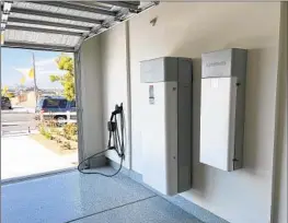  ?? Tony Barboza Los Angeles Times ?? ALL-ELECTRIC homes are the future because they are more efficient. This new model in a Menifee subdivisio­n features a battery storage system in the garage.