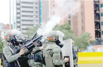  ?? — AFP ?? Riot police clash with demonstrat­ors protesting against President Nicolas Maduro’s government in Caracas on Thursday.