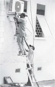  ?? GLADSTONE TAYLOR/PHOTOGRAPH­ER ?? An air-conditioni­ng unit being installed at the Swallowfie­ld Motor Vehicle Examinatio­n Depot in St Andrew yesterday.