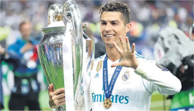  ?? FOTO: AP / NTB SCANPIX ?? FEM: Cristiano Ronaldo markerer at han er den første fotballspi­lleren til å vinne fem Champions League-trofeer.