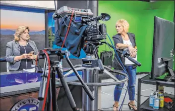  ?? L.E. Baskow Las Vegas Review-Journal @Left_Eye_Images ?? KPVM news director and anchor Deanna O’Donnell, left, confers with Vice President Ronda Van Winkle as they edit her script to record a daily broadcast.