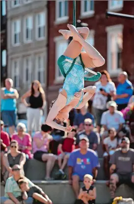  ??  ?? Serenity Smith Forchion, left, performs on Parade Plaza in front of Union Station in New London. A performer, above, laces up her ankle braces.