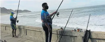  ?? Picture: MICHAEL PINYANA ?? HOOK, LINE AND SINKER: Anglers try and catch something for the pan at the Eastern Beach in East London after believing they had been given the all-clear to cast a bait again.