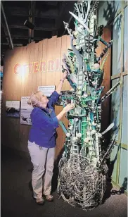  ??  ?? Brenda Walkenhors­t, director of education at the Audubon Aquarium of the Americas in New Orleans, demonstrat­es the sounds of rattles made from bottle caps and incorporat­ed into a sculpture called "Musical Seaweed."