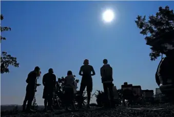  ?? AP PHOTO/TED S. WARREN ?? In 2017, people gather near Redmond, Ore., to view the sun as it nears a total eclipse by the moon.